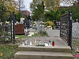 Kwiaty i znicze pod zamkniętym cmentarzami 